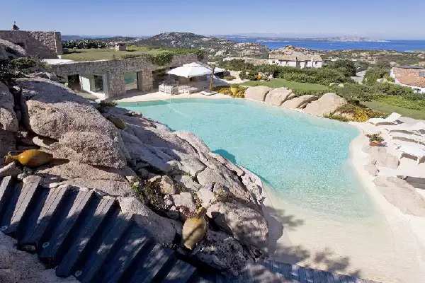 Piscina con spiaggia e bagnasciuga realizzata a Porto Cervo
